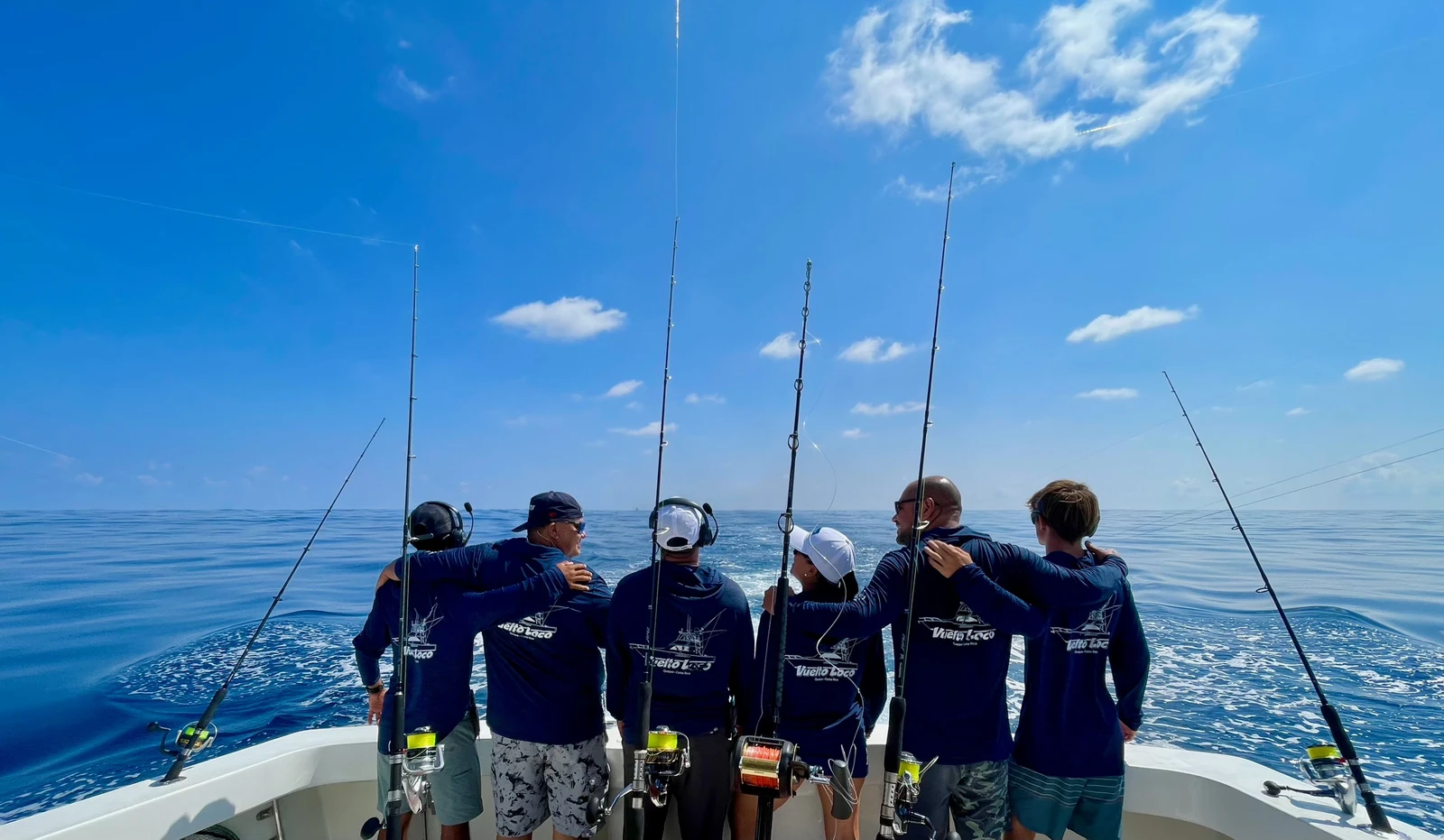 A crew in Vuelto Loco shirts at the bow with rods deployed, offshore from Manuel Antonio