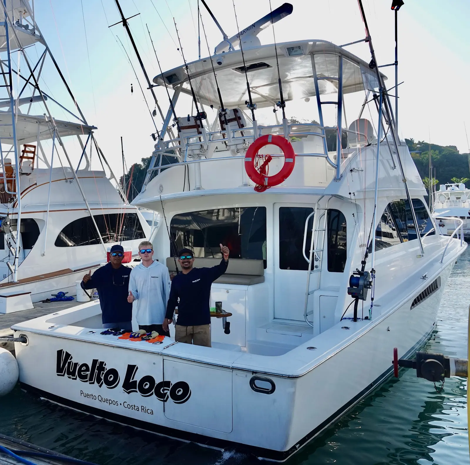 Crew on the transom of the Vuelto Loco dockside at Marina Pez Vela, Quepos